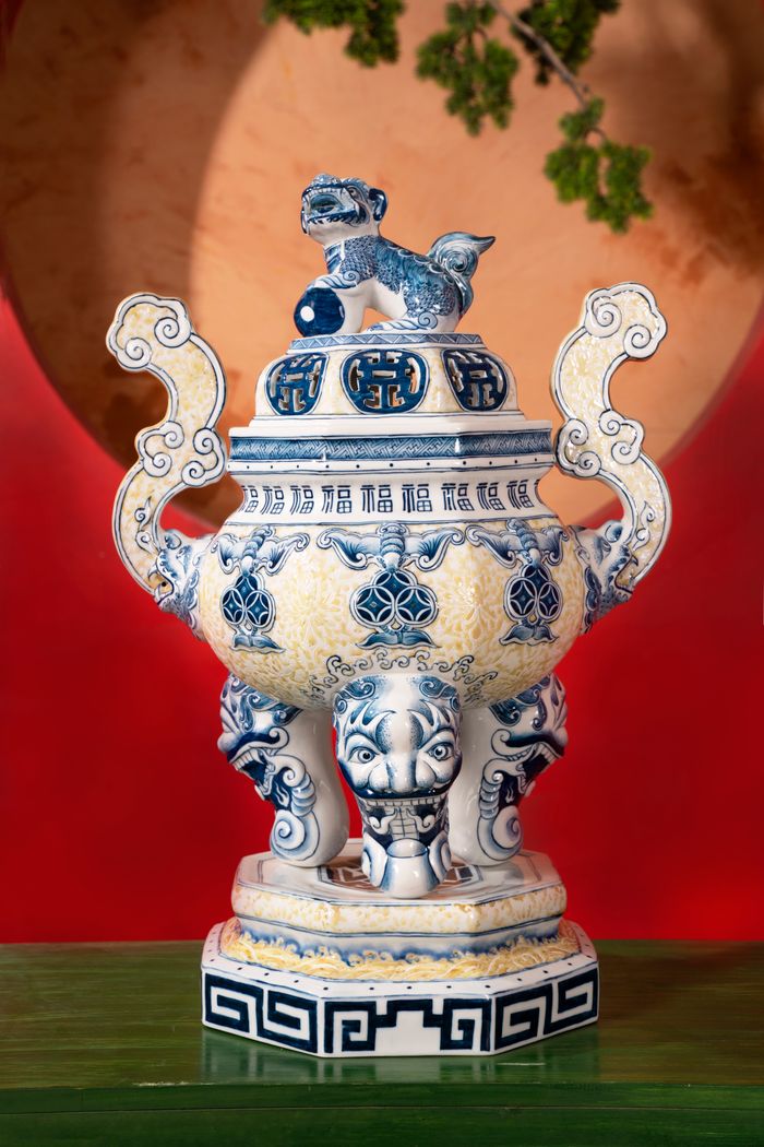 Elegant antique Chinese porcelain incense burner with intricate blue designs and symbolic lion figure.